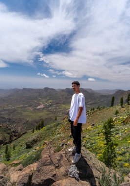 Güneşli bir günde Gran Canaria Adası 'nın tepesinde yürüyüş yapan genç bir adam. Kanarya adaları. İspanya