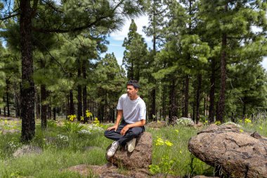 Güneşli bir günde Gran Canaria Adası 'nın tepesinde yürüyüş yapan genç bir adam. Kanarya adaları. İspanya