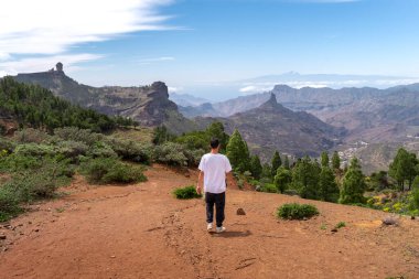 Güneşli bir günde Gran Canaria Adası 'nın tepesinde yürüyüş yapan genç bir adam. Kanarya adaları. İspanya