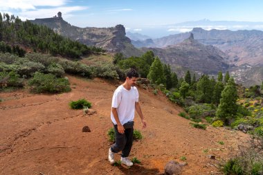 Güneşli bir günde Gran Canaria Adası 'nın tepesinde yürüyüş yapan genç bir adam. Kanarya adaları. İspanya