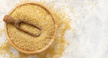 Masanın üstünde beyaz bir tabakta çiğ bulgur buğdayı, kopyalama alanı. Vejetaryen ve vejetaryen, Akdeniz ve Orta Doğu mutfağı. Sağlıklı yaşam tarzı