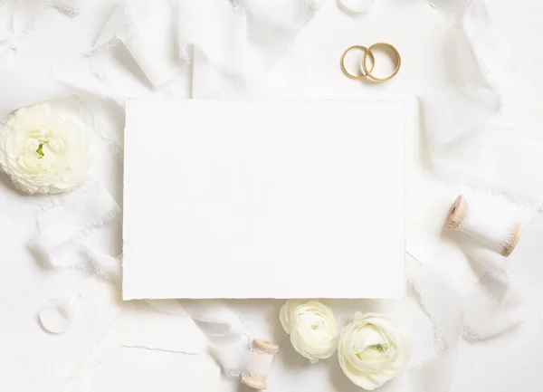靠近奶油玫瑰的空白卡片 白色丝带和结婚戒指 婚纱造型 浪漫的场景与垂直卡片和油腻的花朵平铺在一起 情人节 春天或母亲节的概念 — 图库照片