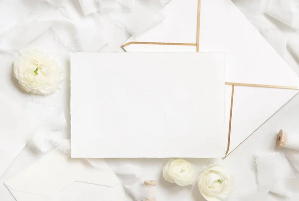 在奶油玫瑰和白色丝带旁边的空白卡片和信封顶视图 婚纱造型 浪漫的场景与横向卡片和油腻的花朵平铺 情人节 春天或母亲节的概念 — 图库照片