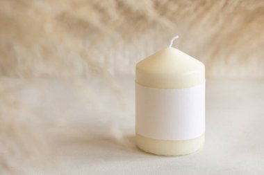 Beyaz masa üzerinde boş kağıt etiketli mum ve kurutulmuş otlar. Kapatın, boşluğu kopyalayın. Minimum marka ambalaj modeli. Ev dekorasyonu, minimal iç dekorasyon, Bohem ya da İskandinav stili