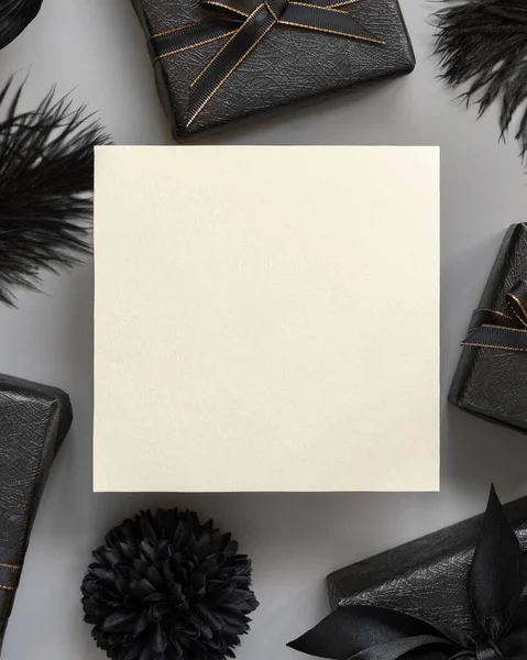 Cartão Branco Entre Caixas Presente Embrulhado Flores Papel Preto Penas — Fotografia de Stock