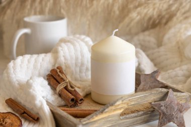 Tarçın yakınındaki tahta tepside boş kağıt etiketli mum, kurutulmuş pampa otları ve doğal dekor, kapatın, kopyalayın. Boho ambalajlama modeli. Kış Noel Evi