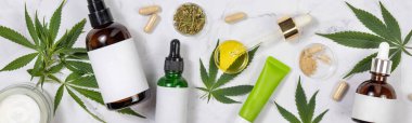 Boş labutlu kozmetik şişeleri, CBD yağlı Pipette kenevir kapsülleri ve mermer masa manzaralı yeşil kenevir sativa yaprakları, Mockup, kopyalama alanı. Organik cilt ürünleri.