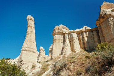 Kapadokya 'daki Aşk Vadisi' nde yaz aylarında mavi gökyüzüne karşı eşsiz jeolojik oluşumlar. Goreme, Nevsehir, Türke 'deki popüler turistik bölge