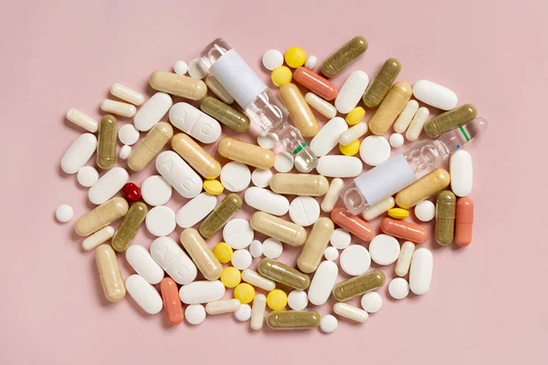 混合医疗胶囊和药丸在浅粉色的顶部视图 药物治疗 服用营养补充剂和维生素 分类药品 — 图库照片
