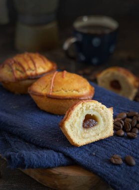 Yumurtalı krema ve vişneli reçelle doldurulmuş pastikciotto leccese pastası. Tipik apulian kahvesi ve kahveyle servis edilen yarım pasticiotties, yakından. Kahve çekirdekleri ile süslenmiş bir masa.
