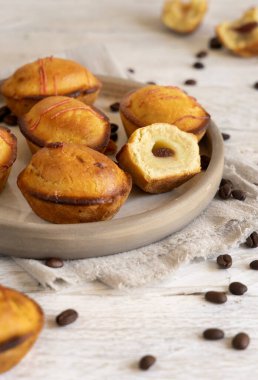 Yumurtalı krema ve vişneli reçelle doldurulmuş pastikciotto leccese pastası. Tipik bir apulian kahvaltısı için servis edilen tabakta tam ve yarım pasticiotties, yakın çekim. Kahve çekirdekleri ile süslenmiş bir masa.