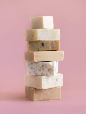 Tower stack of beige handmade soap bars on light pink close up. Natural herbal products for Spa and skin care clipart