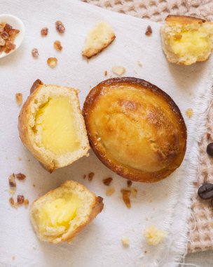 Pasticciotto leccese pastası yumurtalı kremayla dolu, tipik Lecce, İtalya tatlısı. Bej peçetede pasticiotto parçaları, apulian kahvaltısı için tipik tatlı, üst manzara.