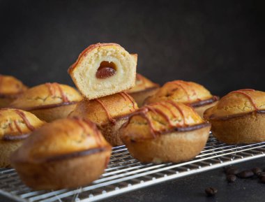 Yumurtalı krema ve vişneli reçelle dolu pastikciotto leccese hamur işi, tipik apulian kahvaltısı, yakın çekim. Karanlık bir masadaki soğutucu askıda yarım pasiflik, kopyalama alanı.