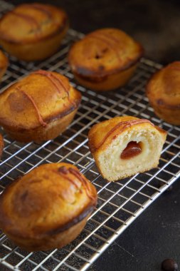 Yumurtalı krema ve vişneli reçelle dolu pastikciotto leccese hamur işi, tipik apulian kahvaltısı, yakın çekim. Karanlık bir masadaki soğutucu askıda tam ve yarım pasiflik.