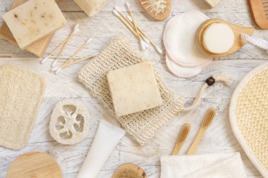 Doğal süngerler, bambu diş fırçaları ve pamuklu çubuklar hijyen malzemelerinin yanındaki sabun koruyucu poşetinde bulunan organik el yapımı bej sabunlar. Doğal bitkisel ürünler