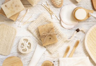 Doğal süngerler, bambu diş fırçaları ve pamuklu çubuklar hijyen malzemelerinin yanındaki sabun koruyucu poşetinde bulunan organik el yapımı bej sabunlar. Doğal bitkisel ürünler