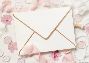 Pembe dekorasyonlar, mühürler ve beyaz masa manzaralı ipek kurdeleler, düğün modeli. Yatay olarak boş bir kartın olduğu romantik bir sahne. Sevgililer Günü, Bahar veya Anneler Günü konsepti