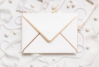 Beyaz çerçeveler, inciler, çakıl taşları ve beyaz masa manzaralı ipek kurdeleler, düğün menüsü modeli. Sevgililer Günü, Bahar veya Anneler Günü davetiyeleri ve selamlar için romantik bir sahne