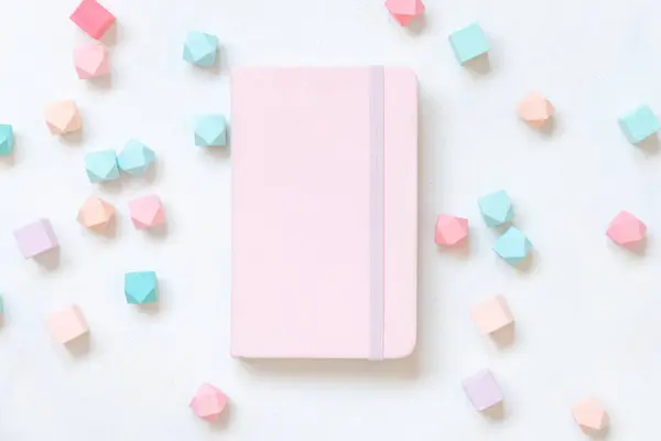Rózsaszín Keménykötésű Notebook Közelében Pasztell Geometriai Dekoráció Fehér Asztal Tetején — Stock Fotó