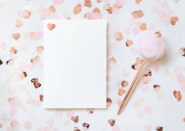 Yatay kart ve zarf pembe kalpler ve beyaz masa manzaralı kürk kalem arasında. Düğün, Sevgililer Günü, Bahar veya Anneler Günü için romantik bir model. 