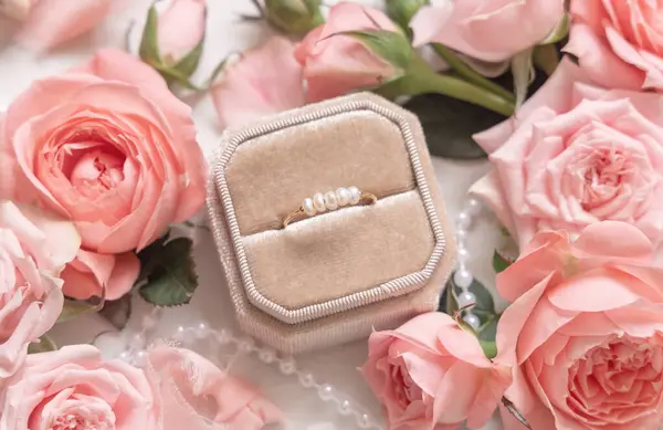 订婚戒指在淡淡的粉红玫瑰和花蕾之间的一个盒子里 为浪漫的婚礼做准备 求婚概念 情人节庆祝活动 — 图库照片
