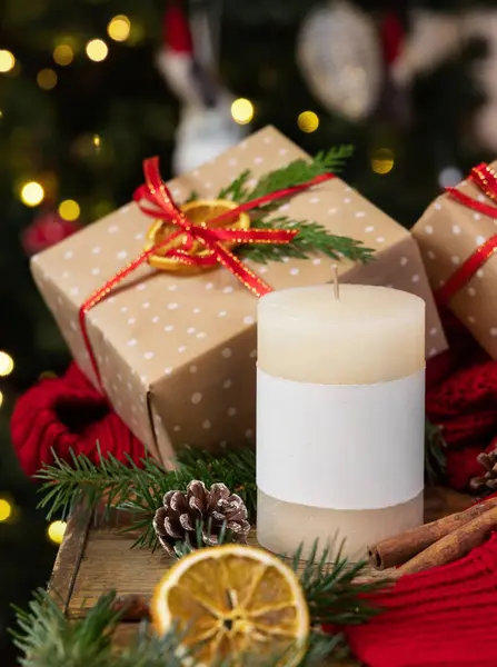 柱子上的蜡烛 贴有空白标签 靠近包装的圣诞礼物 烘干的水果 红色毛衣和冷杉枝条 紧靠着圣诞树灯 复制空间 暖冬家庭气氛模拟 节假日 免版税图库图片