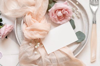 Krem tül kumaş düğümünün yanındaki yatay kart kadife bir kutuda nişan yüzüğünün yanındaki plakanın üst kısmında, kopyalama alanında. Düğün kırtasiyesi modeli. Boş kartıyla romantik masa yeri