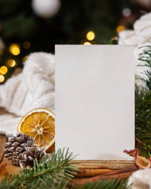 Noel dekoru yakınındaki dikey kart, beyaz örgü süveter ve Noel ağacının parıldayan dallarına karşı köknar dalları, kapatın, boşluğu kopyalayın. Sıcak tatil aile selamı, atmosferik model