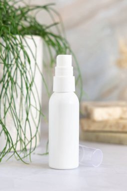 Beyaz sprey kozmetik şişe beyaz mermer üzerinde saksı yeşili bitki ve sabun barları karşı banyoda, yakın çekim, ambalaj modeli. Yüz bakımı, toner veya mikiler için doğal kozmetik ürünü