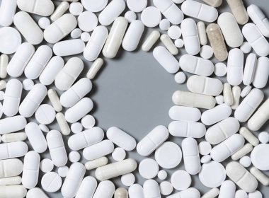 Beyaz tıbbi kapsüller ve hapların karışımı. Ortasında fotokopi alanı var. Tıbbi tedavi için. Beslenme takviyeleri alıyorum. Çeşitli ilaç ürünleri.