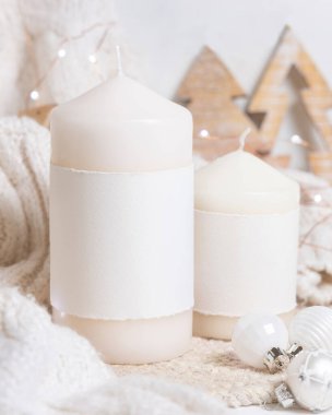 Beyaz örgü süveterin yanında boş yatay etiketli sütun mumu, ahşap Noel dekoru ve takılar, fotokopi alanı. Kış atmosferik modelleme, kırsal ya da İskandinav tarzı ev
