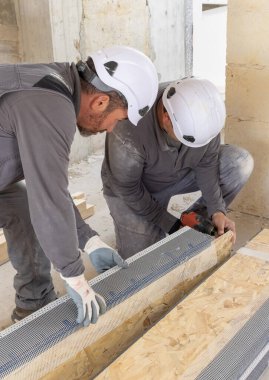 Marangozlar ahşap tahta üzerinde çalışarak inşaat malzemesi veya ahşap mobilya üretiyorlar. Profesyonel elektrikli kablosuz tornavida kullanan ustalar. ÇEVİRİ