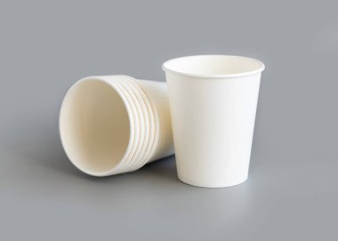 Tek kullanımlık beyaz bardaklar gri renkte izole edilmiş. Grafikler ve reklamlar için şablon, model. Çevre dostu, sürdürülebilir sofra takımı. Sıfır plastik kavram