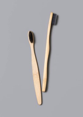 Açık gri arkaplan manzaralı iki biyolojik çözünebilir bambu diş fırçası, boşluğu kopyala. Sıfır atık ve plastik kavram yok