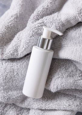 White blank cosmetic one pump cream bottle on light grey towel in bathroom top view, brand packaging mockup. Natural herbal cosmetic product for daily facecare, copy space clipart