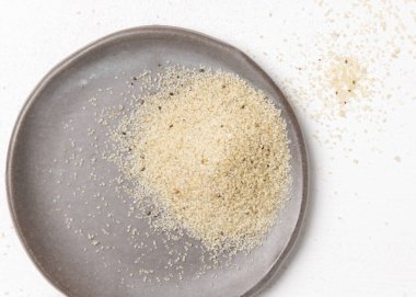 Beyaz masa görünümlü çiğ fonio tohumlu gri tabak, boşluğu kopyala. Afrika 'nın antik sahte tahtaları. Organik süper yiyecekler. Sağlıklı gıda konsepti. Glütensiz alternatif tohumlar