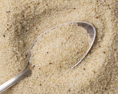 Metal kaşık sahibi çiğ fonio çekirdekleri üst görünüm. Afrika 'nın antik sahte tahtaları. Organik süper yiyecekler. Sağlıklı gıda konsepti. Glütensiz alternatif tohumlar