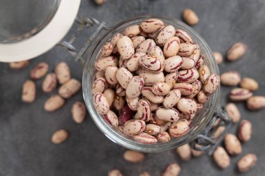 Gri masa manzaralı kurutulmuş fasulye dolu cam kavanoz. Sağlıklı vejetaryen yemekleri, protein kaynakları. Geleneksel Latin Amerikalı kuzen malzemesi