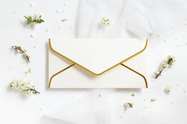 Tül ve yabani eriklerin yanında boş bir zarf. Üst manzara, maket. Pastel bahar partisi tasarımı ya da romantik düğün kırtasiyesi için altın süsleme zarfı. Doğaya yakın ya da anneler günü konsepti  