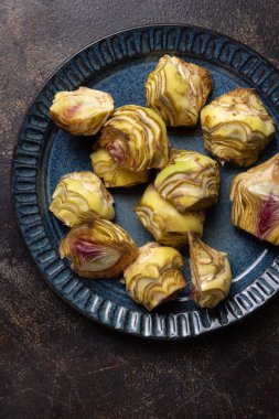 Koyu kırsal masa manzaralı çiğ enginar kalpleriyle dolu bir tabak, kopyalama alanı. Çiftçi pazarından alınmış taze sebzeler. Temizlik yapıyor ve yemek yapmaya hazırlanıyor. İtalyan kuzeni.