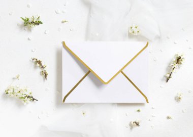 Tül ve yabani eriklerin yanında boş bir zarf. Üst manzara, maket. Pastel bahar partisi tasarımı ya da romantik düğün kırtasiyesi için altın süsleme zarfı. Doğaya yakın ya da anneler günü konsepti  