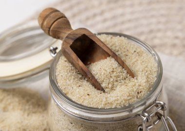 Cam kavanoz çiğ fonio tohumu ve beyaz masa üzerinde ahşap bir kepçe. Afrika 'nın antik sahte tahtaları. Organik süper yiyecekler. Sağlıklı gıda konsepti. Glütensiz alternatif tohumlar