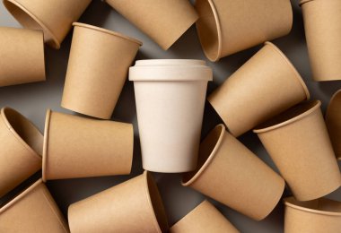 Tek kullanımlık yeni bej kraft kağıt bardaklar ve gri üst manzaralı yeniden kullanılabilir bambu kahve fincanı, fotokopi alanı ile modelleme. Boş kahve fincanları. Plastik ve sürdürülebilir yaşam tarzı kavramı yok 