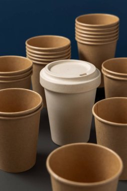 Tek kullanımlık yeni bej kraft kağıt bardaklar ve gri ve mavi yakın plan üzerinde yeniden kullanılabilir bambu kahve fincanı, kopyalama alanı olan maketler. Boş kahve fincanları. Plastik ve sürdürülebilir yaşam tarzı kavramı yok 
