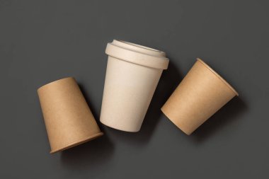Tek kullanımlık yeni bej kraft kağıt bardaklar ve gri üst manzaralı yeniden kullanılabilir bambu kahve fincanı, fotokopi alanı ile modelleme. Boş kahve fincanları. Plastik ve sürdürülebilir yaşam tarzı kavramı yok 