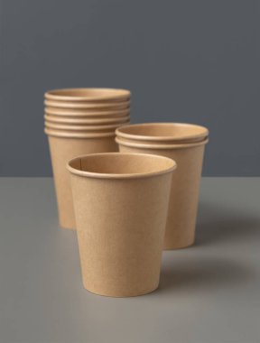 Koyu gri arka planda tek kullanımlık kağıt bardaklar. Reklam alanı olan bir model. Boş karton kahve fincanları düz yerde. Plastik ve sürdürülebilir yaşam tarzı kavramı yok 