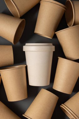Tek kullanımlık yeni bej kraft kağıt bardaklar ve gri üst manzaralı yeniden kullanılabilir bambu kahve fincanı, fotokopi alanı ile modelleme. Boş kahve fincanları. Plastik ve sürdürülebilir yaşam tarzı kavramı yok 