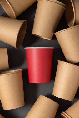 Tek kullanımlık yeni bej kraft kağıt kahve fincanları. Ortasında gri üst görünümü olan bir kırmızı, fotokopi alanı olan. Boş kahve fincanları. Plastik ve sürdürülebilir yaşam tarzı kavramı yok 