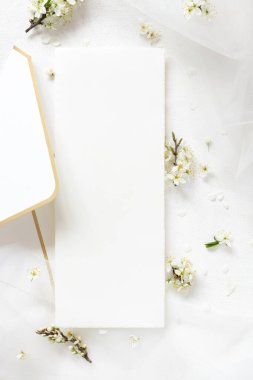 Tül ve yabani eriklerin yanındaki zarfın üzerindeki boş menü kartı. Üst manzara, maket. Bahar partisi tasarımı için Pastel dikey kart ya da romantik düğün kırtasiyesi, doğaya yakın ya da anneler günü 